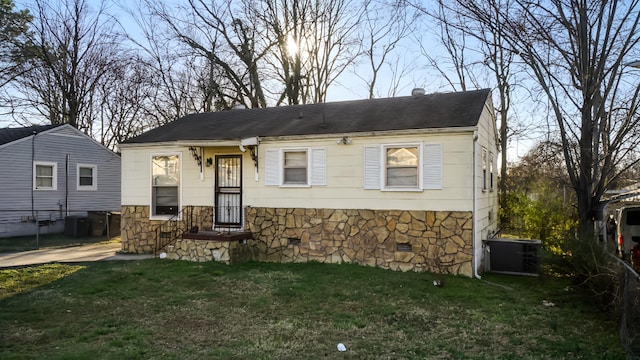 bungalow-style home featuring stone siding, crawl space, a front lawn, and central AC unit