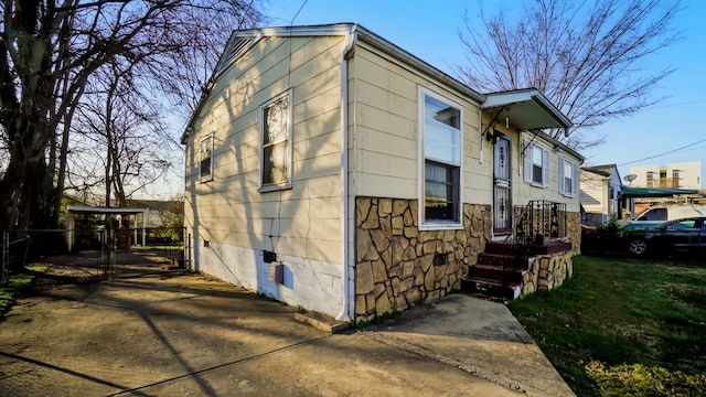 exterior space featuring stone siding, crawl space, and fence