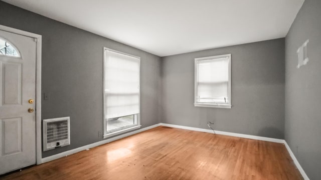 entrance foyer featuring plenty of natural light, wood finished floors, and heating unit