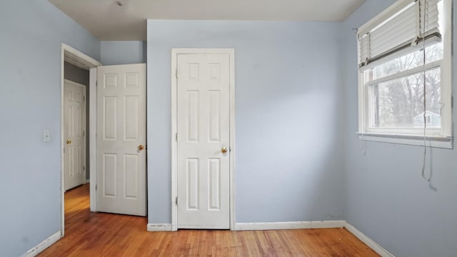 unfurnished bedroom with light wood finished floors and baseboards