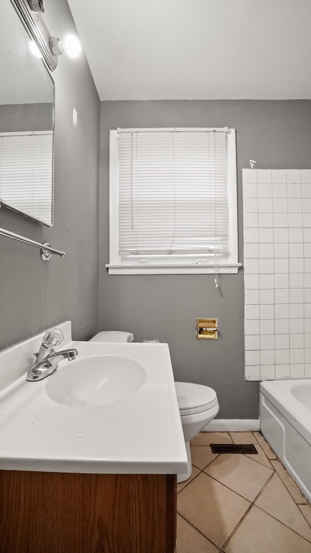 bathroom with vanity, a bathtub, toilet, and tile patterned floors