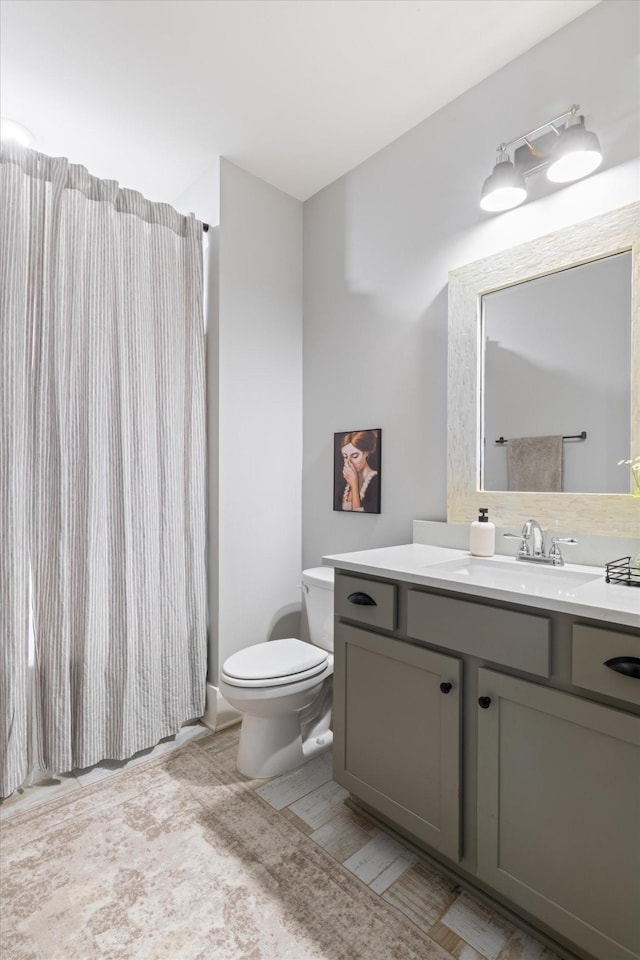 full bathroom with curtained shower, vanity, and toilet