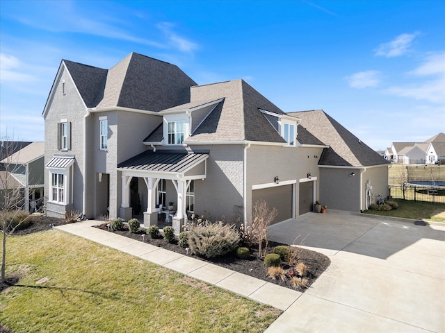 view of front of house featuring brick siding, a shingled roof, concrete driveway, a front lawn, and a trampoline