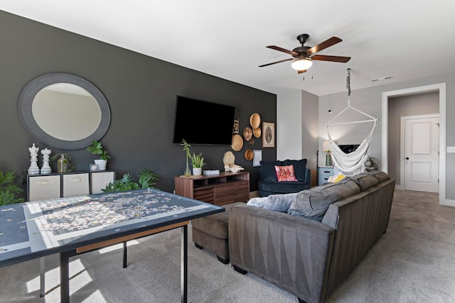 living area with ceiling fan, baseboards, visible vents, and light colored carpet