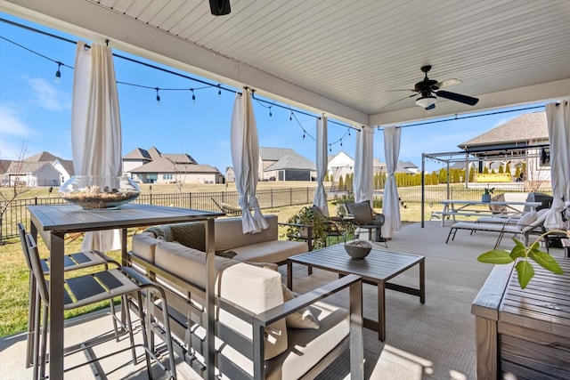 view of patio / terrace with a ceiling fan, a residential view, outdoor lounge area, and fence