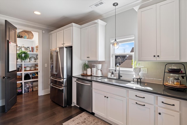 kitchen featuring visible vents, dark wood-type flooring, stainless steel appliances, white cabinetry, and a sink