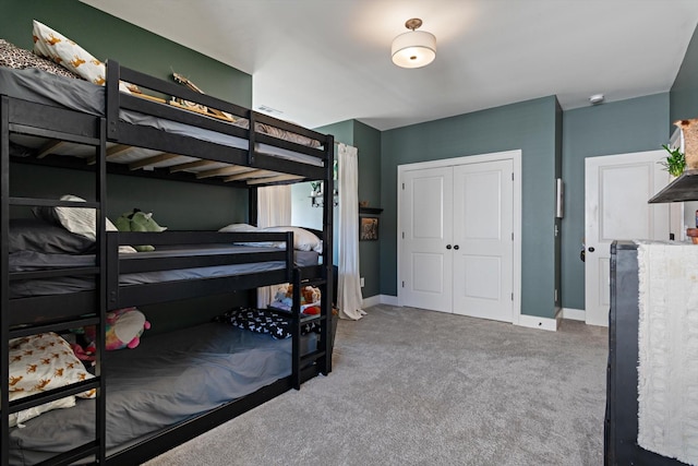 carpeted bedroom featuring a closet and baseboards