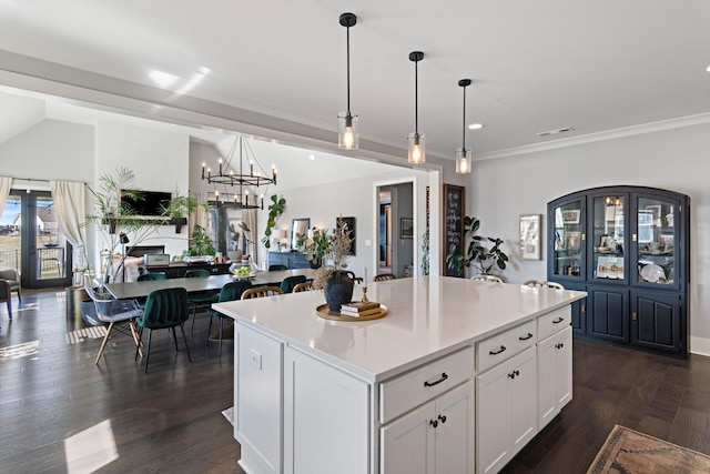 kitchen with open floor plan, dark wood-type flooring, a center island, light countertops, and white cabinetry