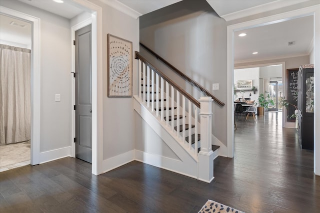 stairs with visible vents, baseboards, wood finished floors, crown molding, and recessed lighting