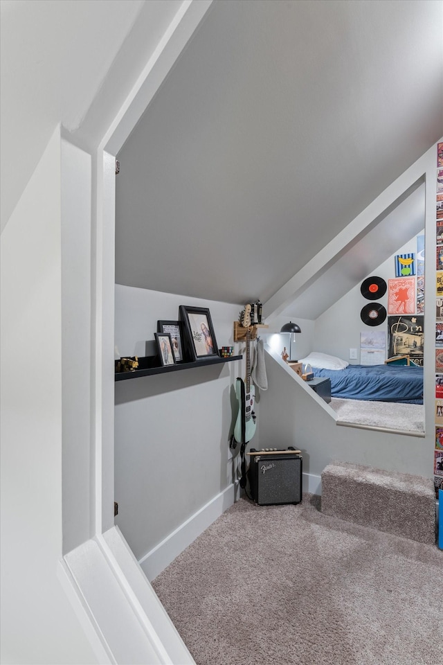 interior space featuring carpet, lofted ceiling, and baseboards