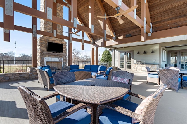 view of patio / terrace featuring an outdoor living space with a fireplace, fence, and outdoor dining area