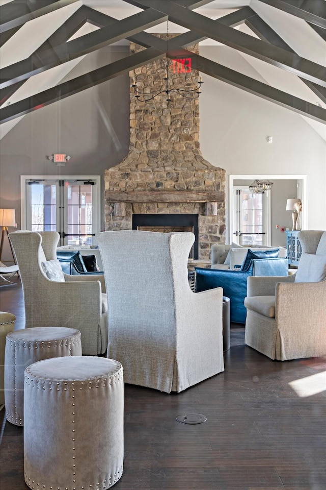 living room featuring plenty of natural light, beamed ceiling, a fireplace, and wood finished floors