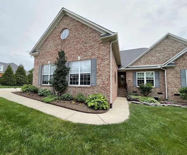 traditional home with brick siding, crawl space, and a front yard