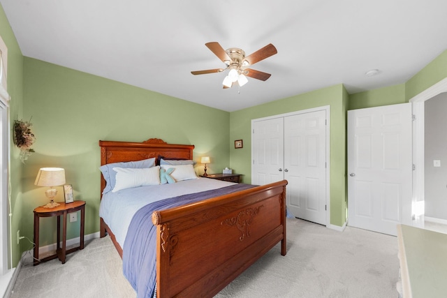 bedroom featuring baseboards, a closet, a ceiling fan, and light colored carpet