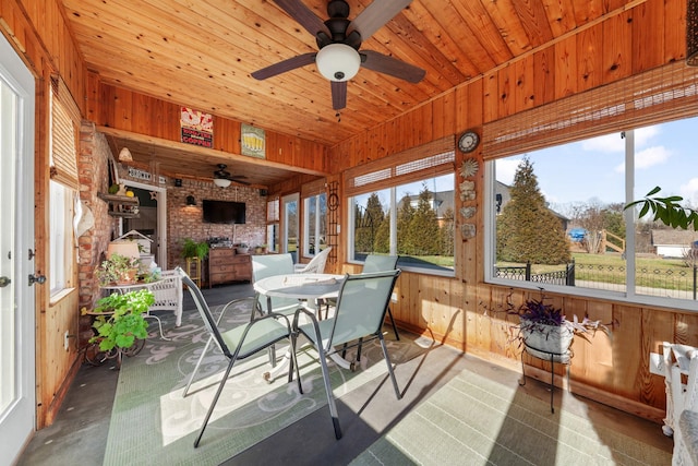 sunroom / solarium with a healthy amount of sunlight, wooden ceiling, and a ceiling fan