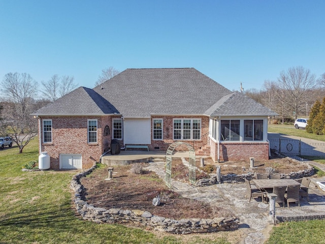 back of house featuring a patio, brick siding, a lawn, and roof with shingles