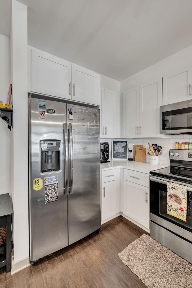 kitchen with stainless steel appliances, white cabinetry, light countertops, tasteful backsplash, and dark wood finished floors