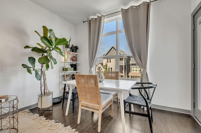 dining area with baseboards and wood finished floors