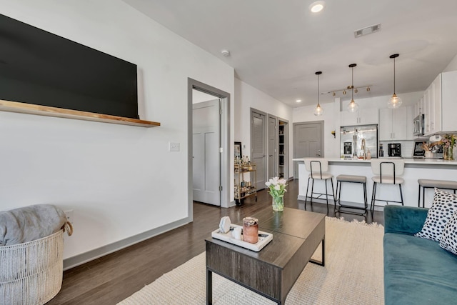 living area with dark wood-style flooring, recessed lighting, visible vents, and baseboards