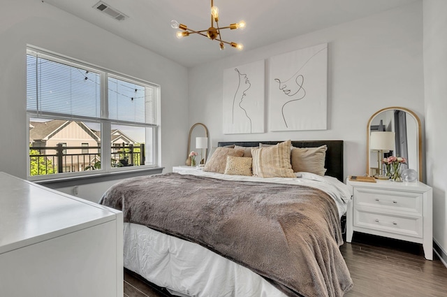 bedroom featuring dark wood-style flooring, visible vents, and a notable chandelier