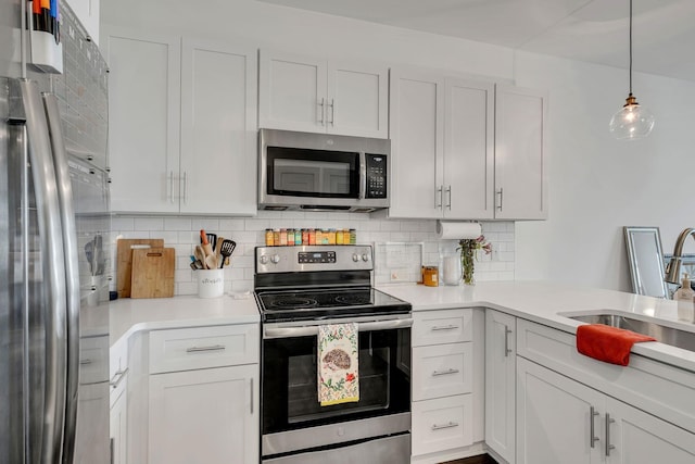 kitchen with a sink, light countertops, appliances with stainless steel finishes, and backsplash