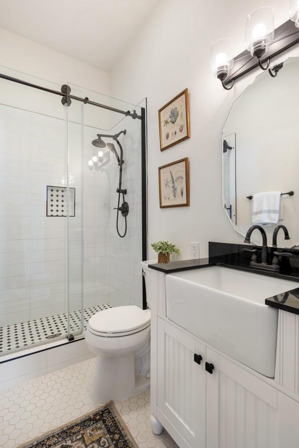 bathroom featuring toilet, a stall shower, tile patterned floors, and vanity