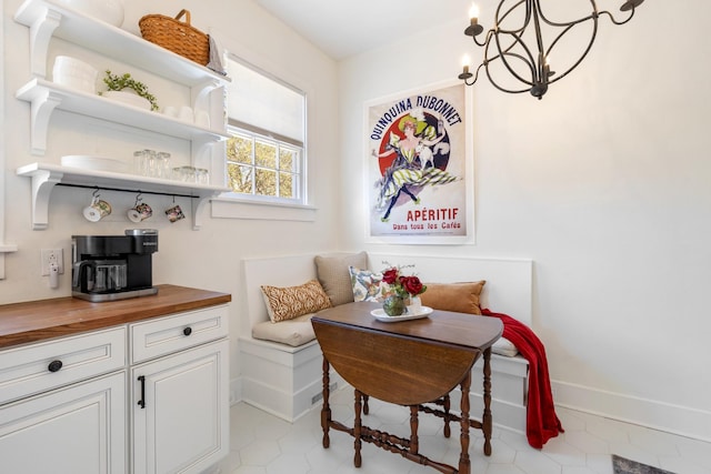 dining space featuring baseboards, breakfast area, and a notable chandelier