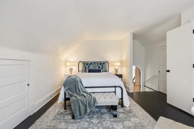 bedroom with lofted ceiling, wood finished floors, and baseboards