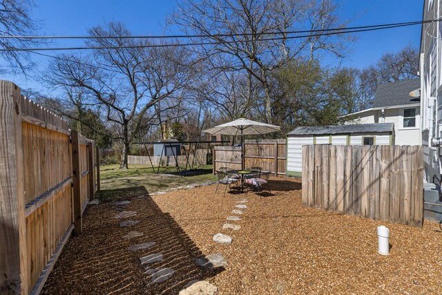 view of yard featuring an outbuilding, a storage shed, and a fenced backyard