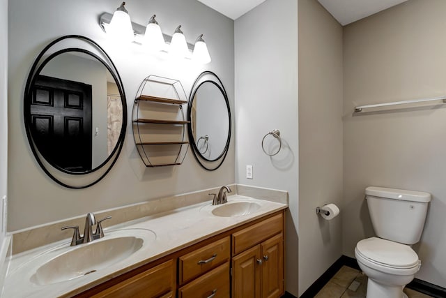 full bath featuring double vanity, a sink, toilet, and baseboards