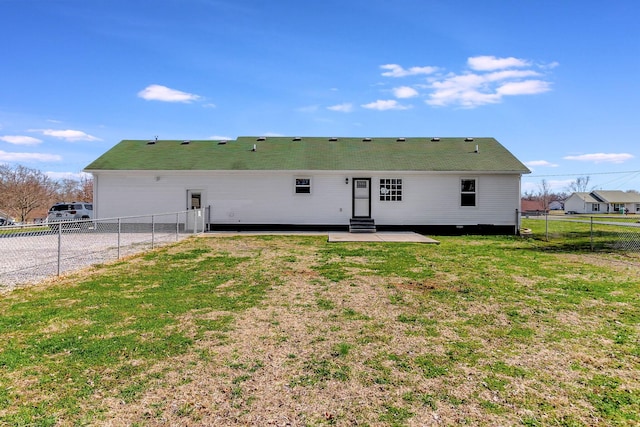 view of front facade featuring entry steps, a fenced backyard, and a front lawn