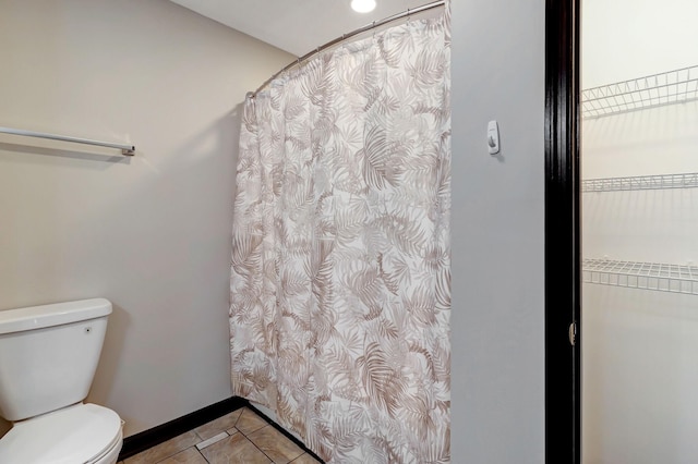 full bath with toilet, baseboards, a shower with shower curtain, and tile patterned floors