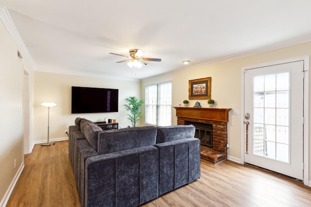 living room featuring ornamental molding, a fireplace, and light wood finished floors