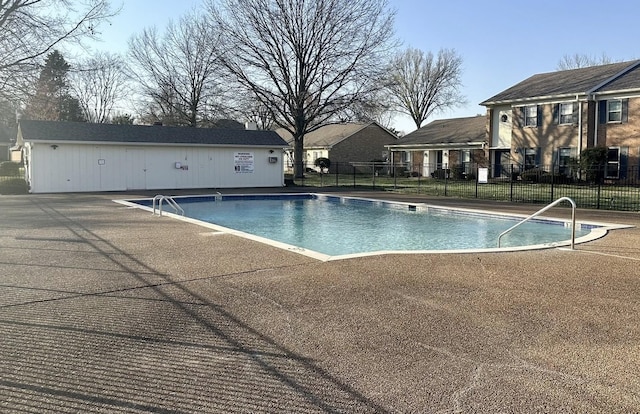 pool with a patio and fence