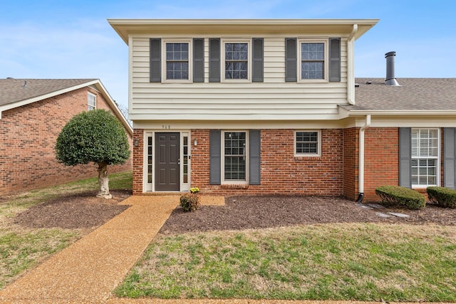 colonial house featuring brick siding