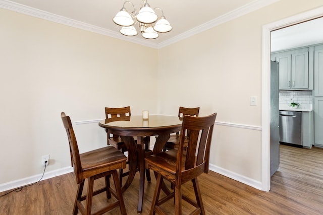 dining area with ornamental molding, baseboards, an inviting chandelier, and wood finished floors