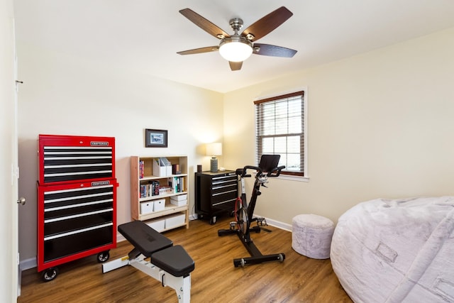 workout area with ceiling fan, baseboards, and wood finished floors