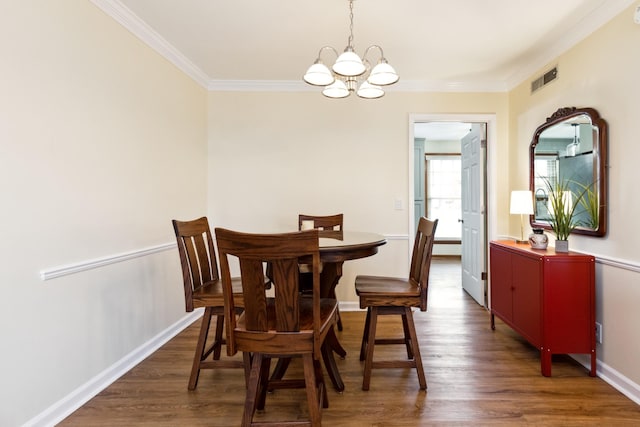 dining space featuring ornamental molding, visible vents, baseboards, and wood finished floors