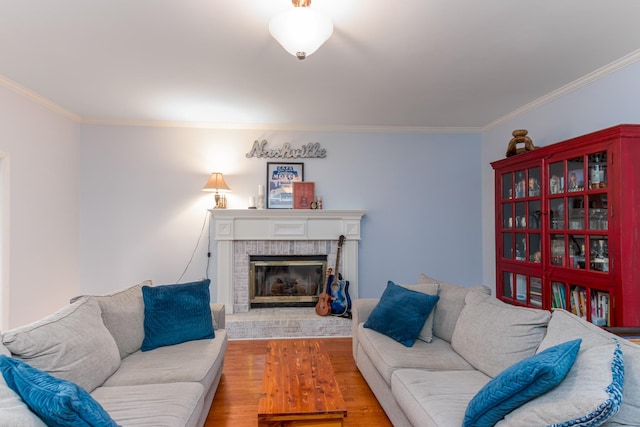 living area with crown molding, a fireplace, and wood finished floors