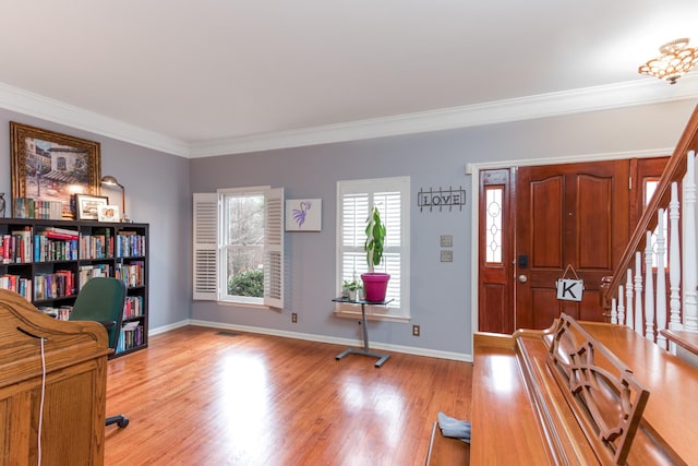 foyer with light wood finished floors, baseboards, stairway, and crown molding