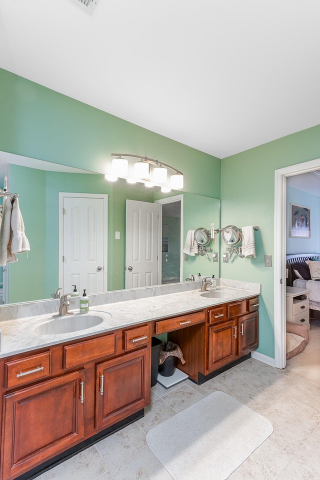 ensuite bathroom featuring connected bathroom, a sink, and double vanity