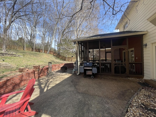 view of patio / terrace with area for grilling, fence, and a sunroom