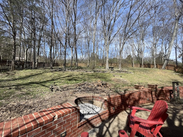 view of yard featuring an outdoor fire pit and fence