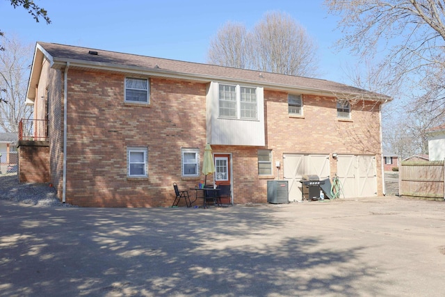 back of property featuring brick siding, fence, and central air condition unit