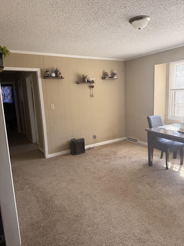 unfurnished office featuring carpet floors, visible vents, ornamental molding, and a textured ceiling