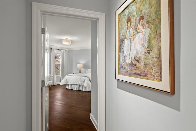 hall with crown molding, baseboards, and wood finished floors