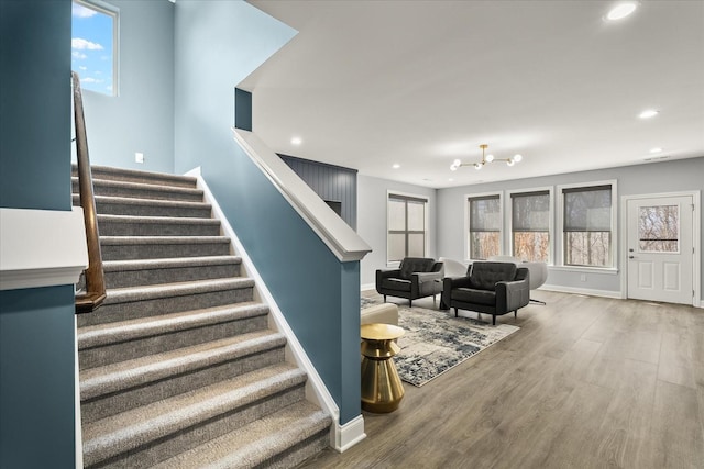 stairs with baseboards, wood finished floors, and recessed lighting