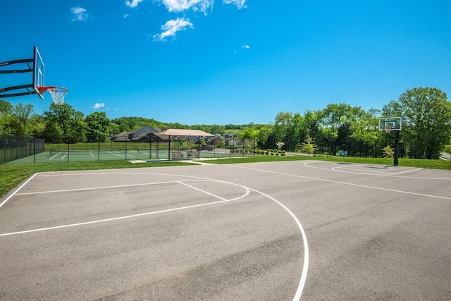 view of sport court with a tennis court, community basketball court, and fence