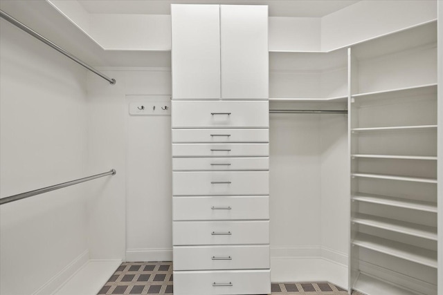 walk in closet with dark floors