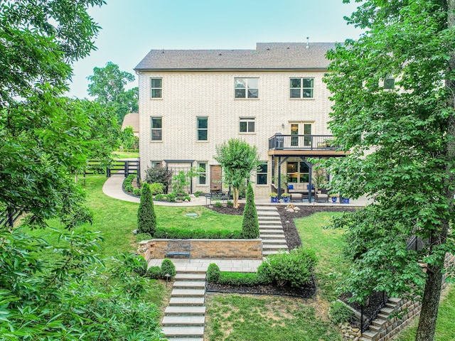 rear view of property featuring brick siding, stairway, a lawn, and a patio